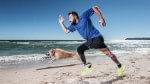 utilisateur challenger court sur la plage avec son chien