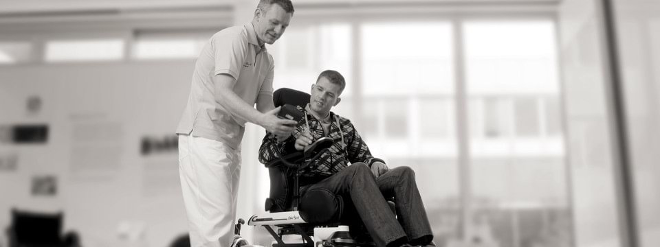 Un homme en fauteuil roulant se fait conseiller par un spécialiste